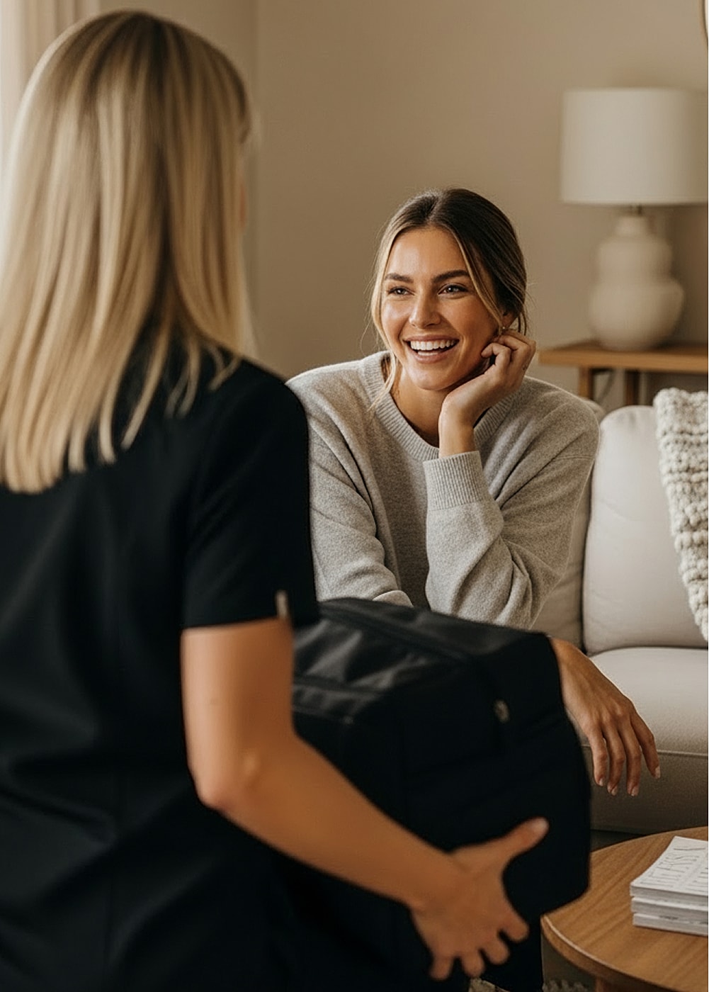 Two women smiling and chatting indoors.